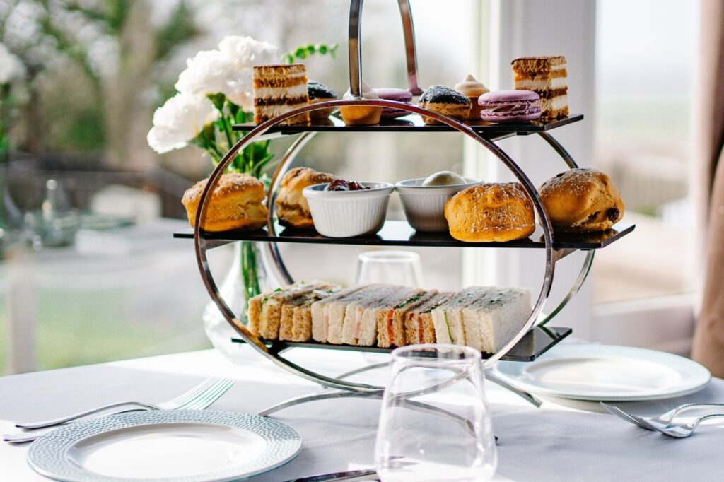 Full cotswold afternoon tea ona metallic stand, layed on a table in the cotswold room at hatton court hotel.