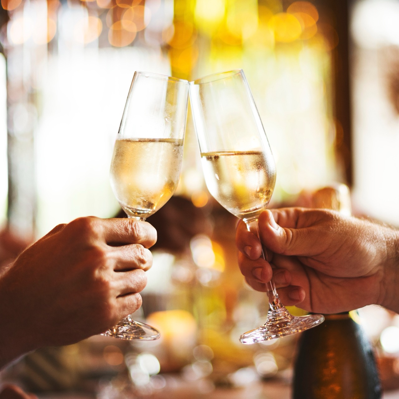 2 glasses of sparkling wine being hit together for a cheers moment at hatton court hotel while at a baby shower.