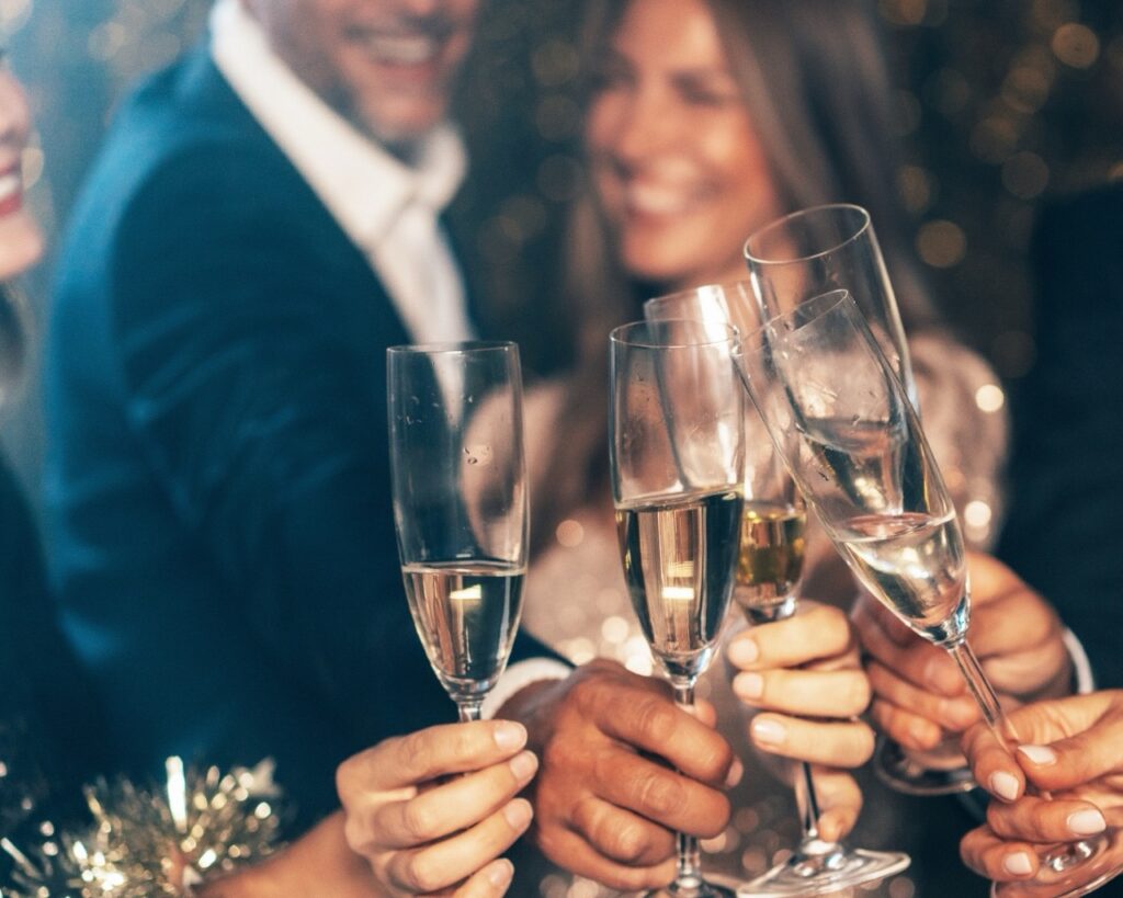 Couples enjoying a glass of prosecco while making a toast while staying at hatton court hotel for christmas