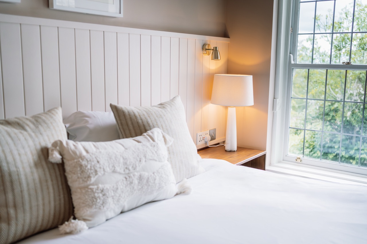 Close up of cushions on a bed in a newly refurbished heritage room at hatton court hotel