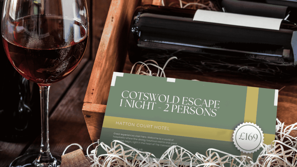 Hatton Court Cotswold Escape Voucher in front of some wine on a bed of hay